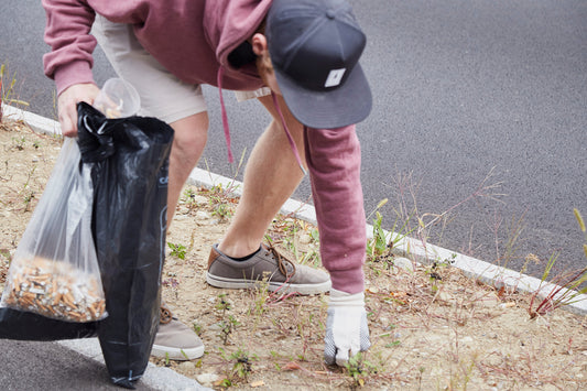 Person collects garbage at the roadside - sustainable action on Good Deed Day for more environmental protection.